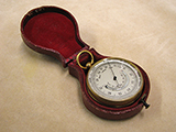 Late 19th century pocket barometer with curved thermometer in outer case